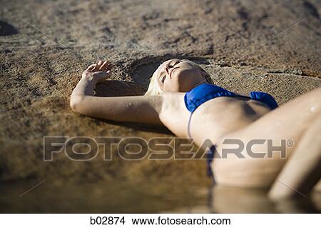 Young woman lying, lake side View Large Photo Image Picture - Young woman lying, lake side. Fotosearch