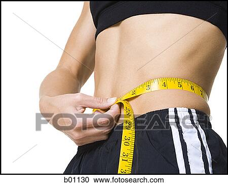 Young woman measuring her waist View Large Photo Image Stock Image - Young woman measuring her waist. Fotosearch