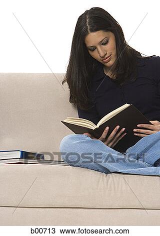 Stock Image - Young woman reading a book. Fotosearch
