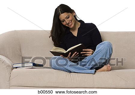 Young woman sitting on a couch and reading a book View Large Photo Image Stock Image - Young woman sitting on a couch and reading a book. Fotosearch