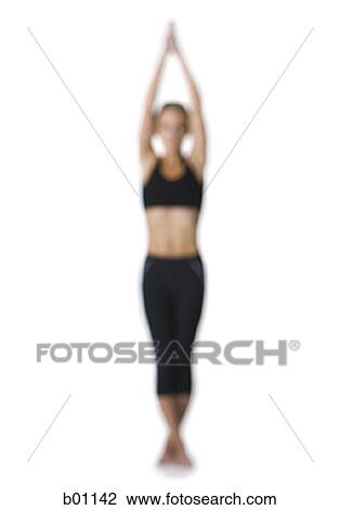 Young woman standing in a yoga posture View Large Photo Image Stock Image - Young woman standing in a yoga posture. Fotosearch