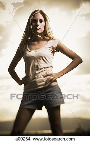 Young woman standing with her hands on her hips View Large Photo Image Picture - Young woman standing with her hands on her hips. Fotosearch