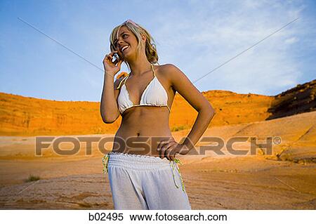 Young woman talking on a mobile phone View Large Photo Image Stock Photography - Young woman talking on a mobile phone. Fotosearch