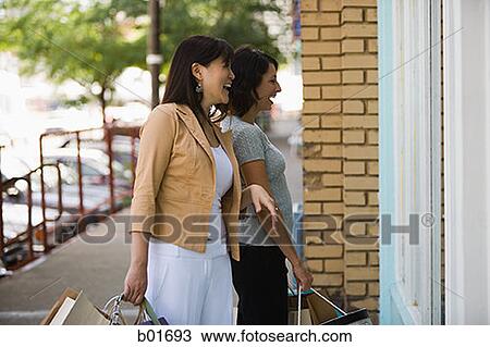 Young woman with an adult woman carrying shopping bags View Large Photo Image Stock Image - Young woman with an adult woman carrying shopping bags. Fotosearch