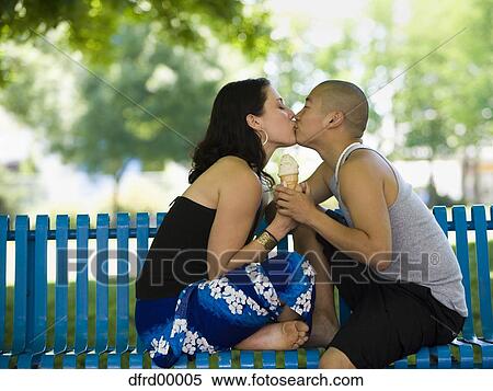 偶力がキスする 上に 公園のベンチ で アイスクリームコーン ストックフォト 写真素材 Dfrd Fotosearch