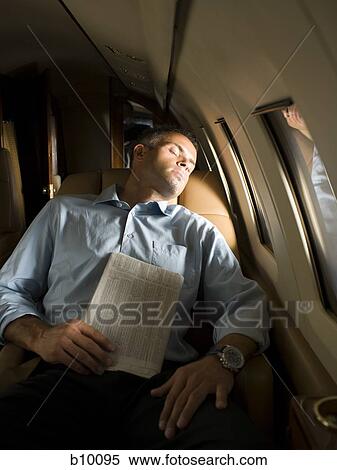 A businessman sleeping in an airplane View Large Photo Image Stock Photography - A businessman sleeping in an airplane. Fotosearch