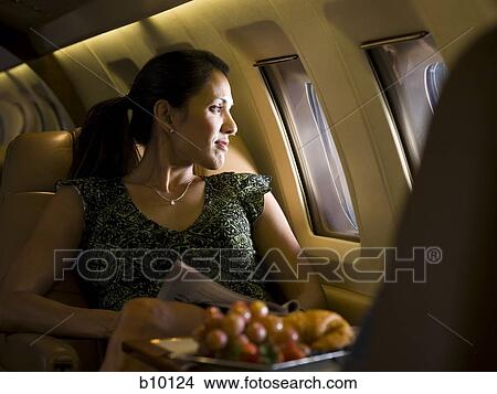 Picture - A businesswoman looking out an airplane window. Fotosearch