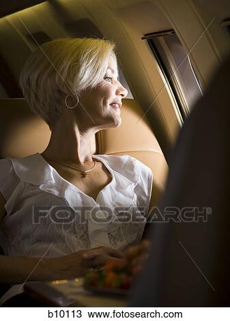 A businesswoman looking out an airplane window View Large Photo Image Stock Image - A businesswoman looking out an airplane window. Fotosearch