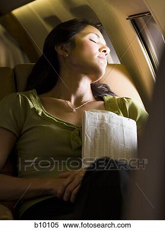 A businesswoman sleeping in an airplane View Large Photo Image Stock Photography - A businesswoman sleeping in an airplane. Fotosearch