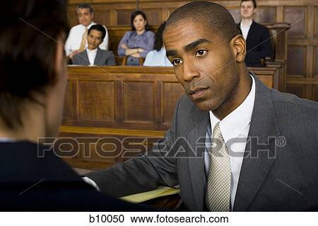 A male lawyer looking at another lawyer in a courtroom View Large Photo Image Stock Image - A male lawyer looking at another lawyer in a courtroom. Fotosearch