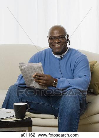 A man holding a newspaper and smiling View Large Photo Image Stock Image - A man holding a newspaper and smiling. Fotosearch