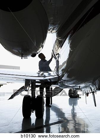 A man inspecting an airplane View Large Photo Image Stock Image - A man inspecting an airplane. Fotosearch