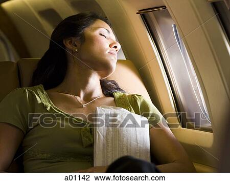 A woman sleeping in an airplane View Large Photo Image Stock Image - A woman sleeping in an airplane. Fotosearch