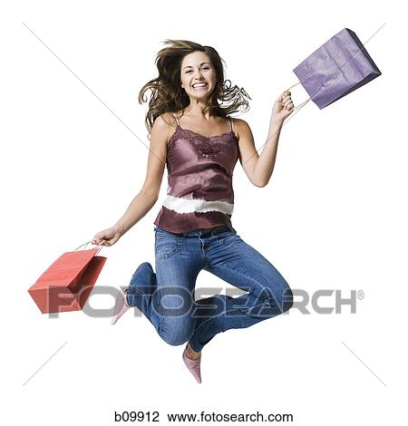 A young woman jumping and holding shopping bags View Large Photo Image Stock Image - A young woman jumping and holding shopping bags. Fotosearch