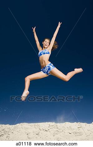 A young woman jumping at the beach View Large Photo Image Stock Photo - A young woman jumping at the beach. Fotosearch