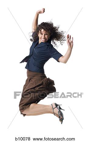 A young woman jumping with her arms raised View Large Photo Image Stock Photo - A young woman jumping with her arms raised. Fotosearch