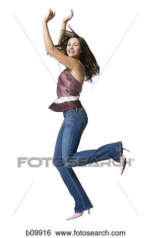 Stock Photograph - A young woman jumping with her arms raised. Fotosearch