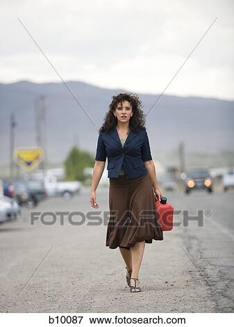 A young woman walking with a gas can View Large Photo Image Stock Photo - A young woman walking with a gas can. Fotosearch