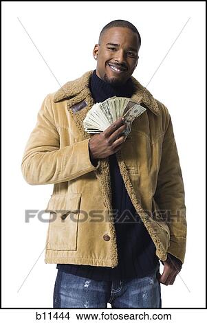 Picture - African American holding a pile of dollar bills. Fotosearch