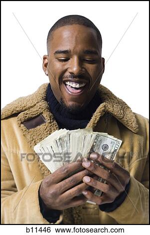 Stock Photograph - African American holding a pile of dollar bills. Fotosearch