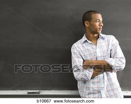 African American male student leaning against chalkboard View Large Photo Image Stock Photo - African American male student leaning against chalkboard. Fotosearch