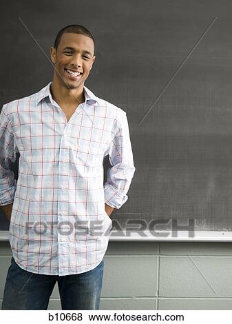 African American male student leaning against chalkboard View Large Photo Image Stock Photo - African American male student leaning against chalkboard. Fotosearch
