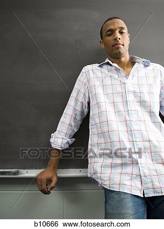 African American male student leaning against chalkboard View Large Photo Image Stock Photograph - African American male student leaning against chalkboard. Fotosearch