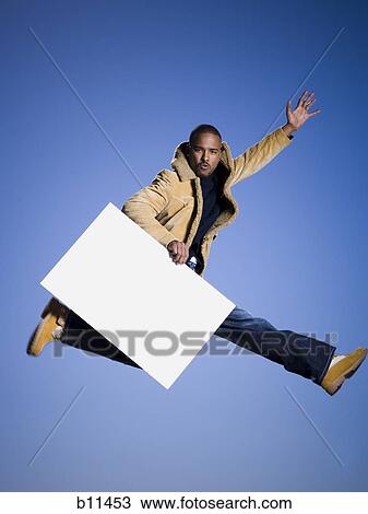African American man jumping and holding a blank sign View Large Photo Image Stock Image - African American man jumping and holding a blank sign. Fotosearch