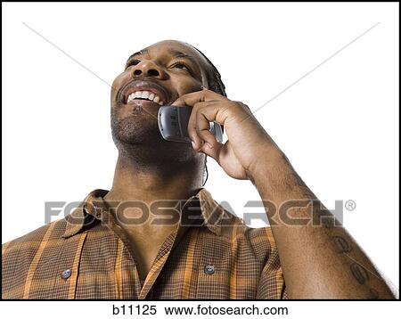 Stock Photography - African American man smiling and talking on cell phone. Fotosearch
