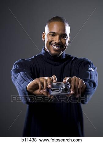 Stock Photo - African American taking picture with digital camera. Fotosearch