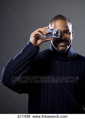 Stock Photo - African American taking picture with digital camera. Fotosearch