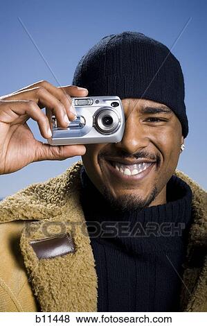 Stock Photo - African American taking picture with digital camera. Fotosearch