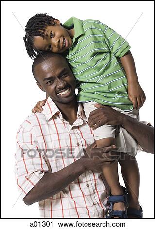 An African American father carries his son on his shoulder while they smile at the camera View Large Photo Image Stock Image - An African American father carries his son on his shoulder while they smile at the camera. Fotosearch