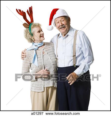 An elderly couple wearing Christmas hats laugh together View Large Photo Image Stock Photo - An elderly couple wearing Christmas hats laugh together. Fotosearch