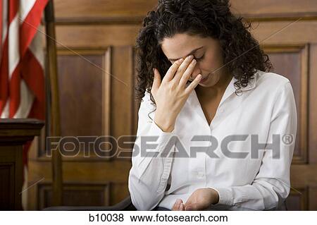 An upset female witness sitting in a courtroom View Large Photo Image Stock Photo - An upset female witness sitting in a courtroom. Fotosearch