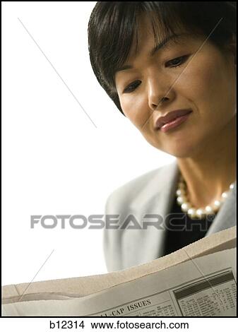 Picture - Asian woman reading a newspaper. Fotosearch