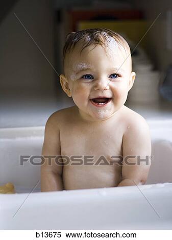 Stock Photography - Baby bathing in sink. Fotosearch
