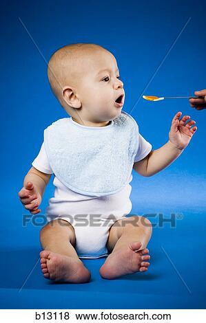 Baby eating baby food View Large Photo Image Stock Photo - Baby eating baby food. Fotosearch