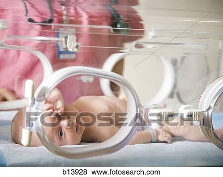 Stock Photo - Baby in incubator with female nurse. Fotosearch