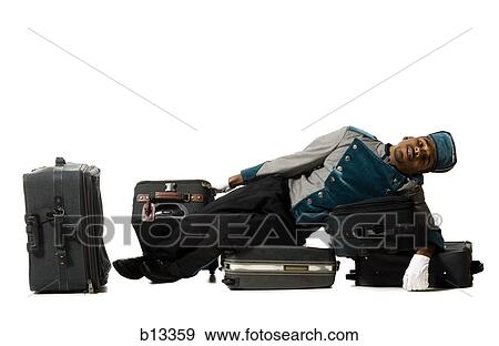 Bellboy lying down on luggage View Large Photo Image Stock Photo - Bellboy lying down on luggage. Fotosearch