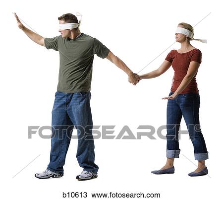Stock Image - Blindfolded young man leading to a blindfolded young woman. Fotosearch