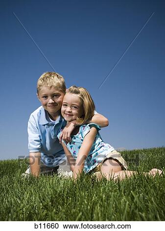 Boy and girl playing on a hill View Large Photo Image Stock Image - Boy and girl playing on a hill. Fotosearch
