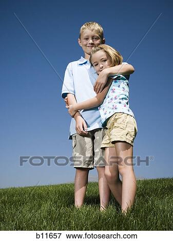 Boy and girl playing on a hill View Large Photo Image Stock Photo - Boy and girl playing on a hill. Fotosearch
