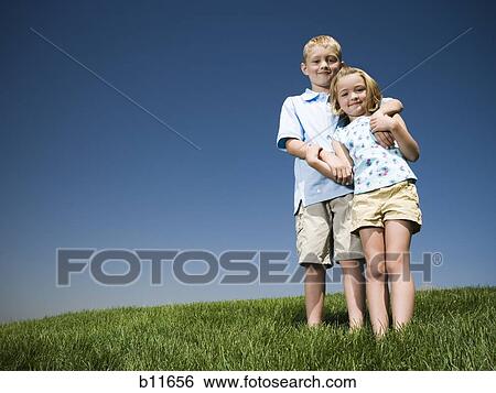 Stock Photograph - Boy and girl playing on a hill. Fotosearch