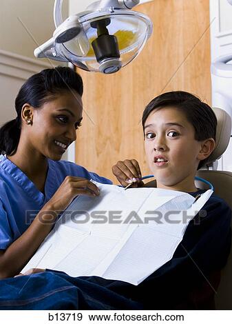 Boy at dentist with hygienist View Large Photo Image Stock Photo - Boy at dentist with hygienist. Fotosearch