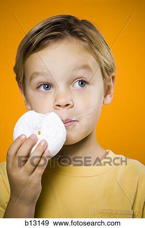 Boy eating donut View Large Photo Image Stock Photo - Boy eating donut. Fotosearch