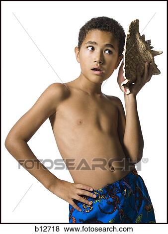Boy listening to conch shell View Large Photo Image Stock Photo - Boy listening to conch shell. Fotosearch