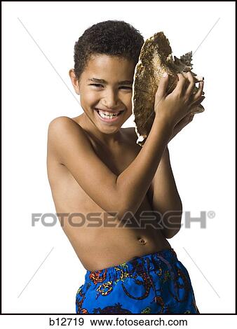Stock Photo - Boy listening to conch shell. Fotosearch
