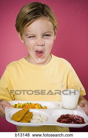Boy making funny face with tray of food View Large Photo Image Stock Photo - Boy making funny face with tray of food. Fotosearch