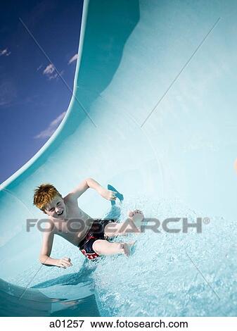 Stock Photo - Boy on a waterslide. Fotosearch
